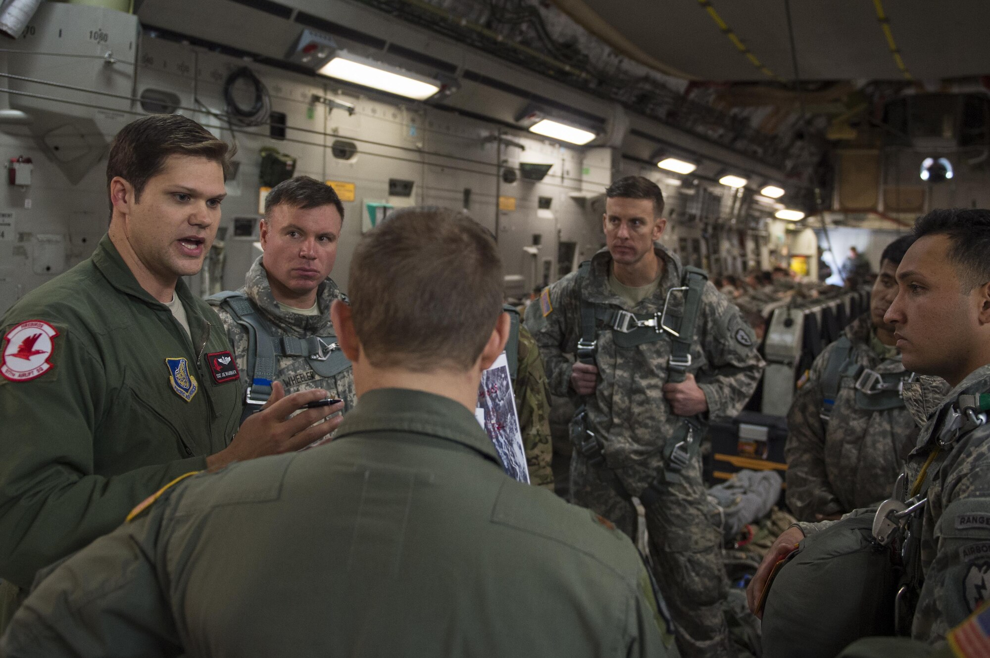 U.S. Air Force Staff Sgt. Joe Braunwarth, a loadmaster assigned to the 517th Airlift Squadron gives a mission brief prior to a training jump with the 4th Infantry Brigade Combat Team (Airborne), 25th Infantry Division at Joint Base Elmendorf-Richardson, Alaska, Oct. 19, 2016. 