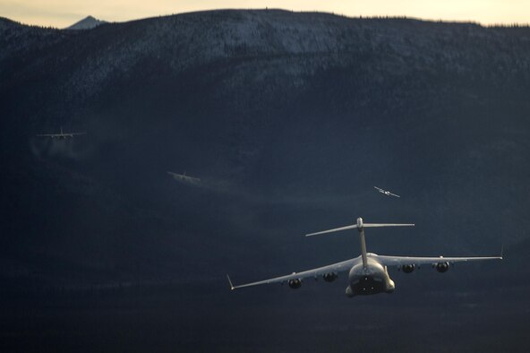 A U.S. Air Force C-17 Globemaster III from Joint Base Elmendorf-Richardson flies behind several C-130J Hercules during a training sortie, Oct. 19, 2016.  Training sorties are imperative to pilot development and overall mission effectiveness. 