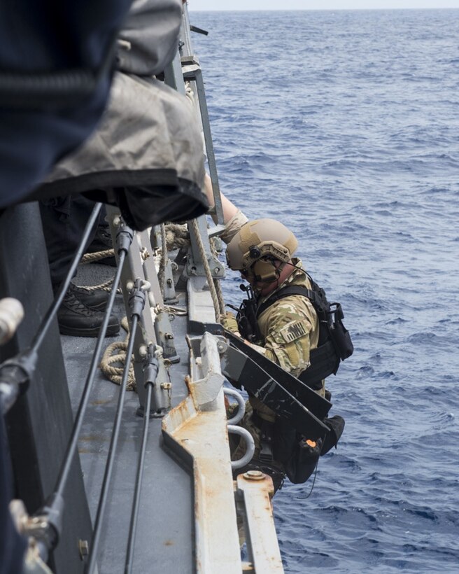 A Coast Guardsman assigned to the U.S. Coast Guard Tactical Law Enforcement Team South prepares to board a rigid-hull inflatable boat (RHIB) from the guided-missile destroyer USS William P. Lawrence (DDG 110). Providing a ready force supporting security and stability in the Indo-Asia Pacific, William P. Lawrence was operating as part of the John C. Stennis Strike Group and Great Green Fleet on a regularly scheduled 7th Fleet deployment. (U.S. Navy photo by Mass Communication Specialist 3rd Class Emiline L. M. Senn/Released)