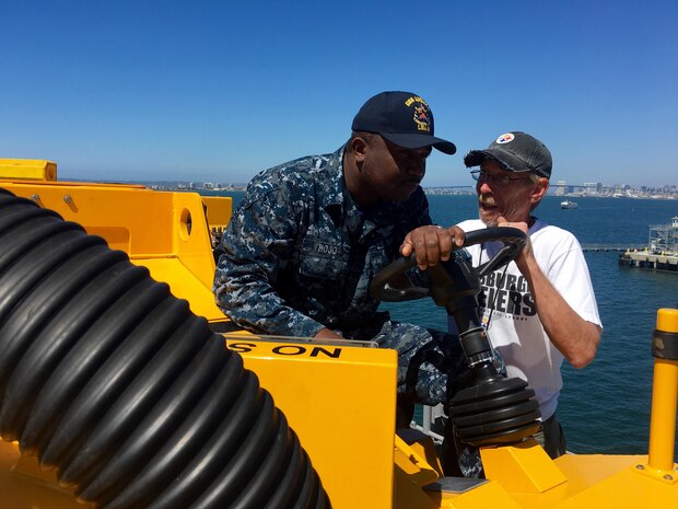 160915-N-IL267-007 SAN DIEGO (Sept. 15, 2016) Tracy Harasti, an environmental protection specialist with Naval Surface Warfare Center, Carderock Division, trains Seaman Uzoma Hojo in the use of the Mobile Cleaning Reclaim and Recovery System on the flight deck of the amphibious assault ship USS America (LHA 6). (U.S. Navy photo by Dustin Q. Diaz/Released)