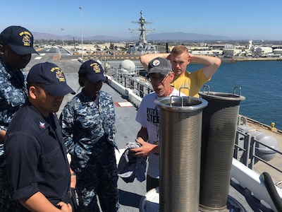 160915-N-IL267-007 SAN DIEGO (Sept. 15, 2016) Tracy Harasti, an environmental protection specialist with Naval Surface Warfare Center, Carderock Division, trains Seaman Uzoma Hojo in the use of the Mobile Cleaning Reclaim and Recovery System on the flight deck of the amphibious assault ship USS America (LHA 6). (U.S. Navy photo by Dustin Q. Diaz/Released)