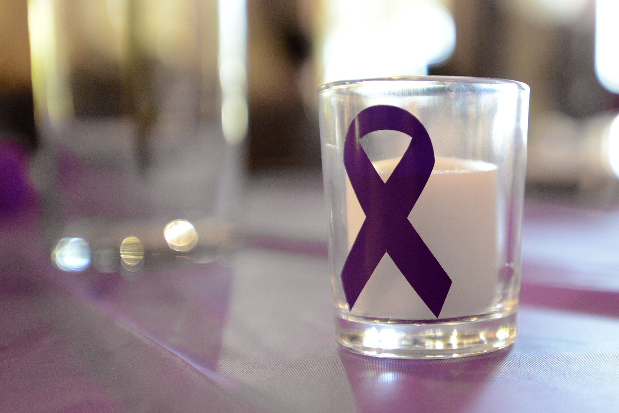 A candle with a purple ribbon signifying Domestic Violence Awareness rests on a table during a Domestic Violence Survivor’s Luncheon at the James Clyburn Intermodal Transportation Center pavilion, Sumter, S.C., Oct. 20, 2016. Nearly 120 people from the Sumter and Shaw Air Force Base communities were present for the luncheon. (U.S. Air Force photo by Airman 1st Class Kelsey Tucker)