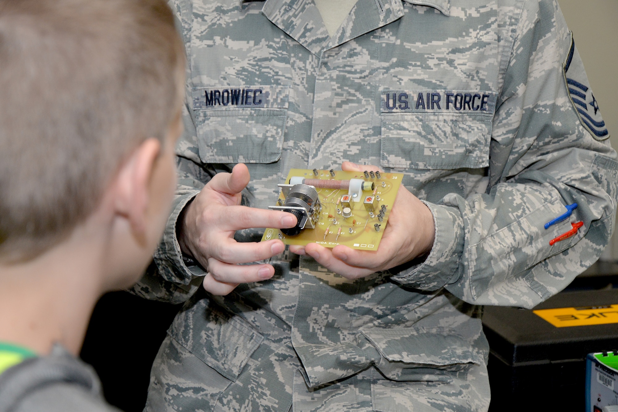 Master Sgt. Robert Mrowiec, 312th Training Squadron course development manager, demonstrates the makeup of a radio to a Wall Middle School student at Brandenburg Hall during a tour on Goodfellow Air Force Base, Texas, Oct. 24, 2016. Mrowiec explained that 312th TRS students are trained on how to make simple radios for use in emergencies. (U.S. Air Force photo by Airman 1st Class Randall Moose)