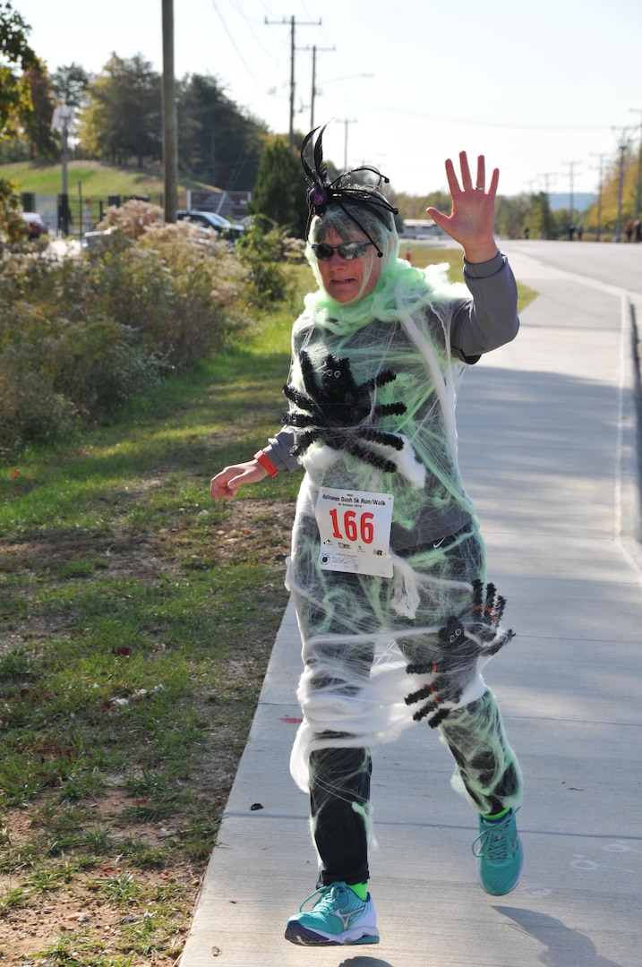 Leslie Mehall of the Defense Contract Audit Agency runs in her prize-winning spiderweb costume at the Monster Dash.
