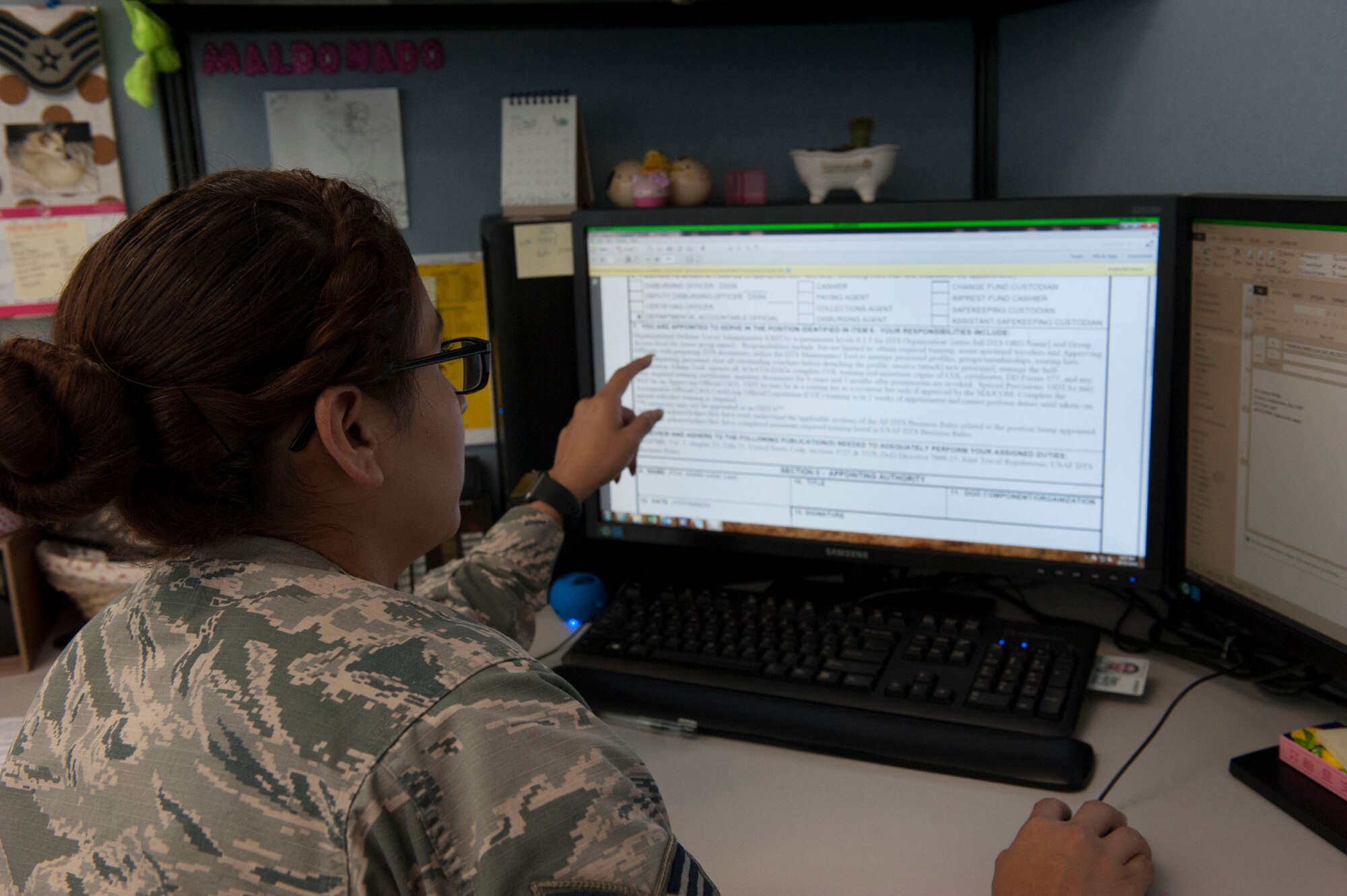 U.S. Air Force Senior Airman Cristina Maldonado, 18th Comptroller Squadron Defense Travel System team lead, references a portion of Defense Document 577 in DTS Oct. 25, 2016, at Kadena Air Base, Japan. The DD 577, once filled out, is routed through the unit’s supervision and allows the proper authorities to view an organization’s information and the different permissions the organization may have. (U.S. Air Force photo by Senior Airman Lynette M. Rolen/Released)  