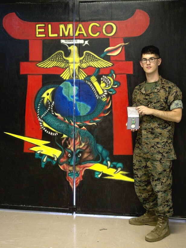Cpl. Ricki D. Clement presents his Navy and Marine Corps Achievement medal he received for exceptional innovation at Camp Kinser, Okinawa, Japan, Oct. 20, 2016. Clement repaired a radio tester unit using a Vehicular Amplifier Unit, saving the Marine Corps nearly $64,000 in logistics and maintenance. Clement, from Houston, Texas, is a micro/miniature repair man with Electronics Maintenance Company, 3rd Maintenance Battalion, Combat Logistics Regiment 35, 3rd Marine Logistics Group, III Marine Expeditionary Force. (U.S. Marine Corps photo by Lance Cpl. Breanna Weisenberger/ Released)