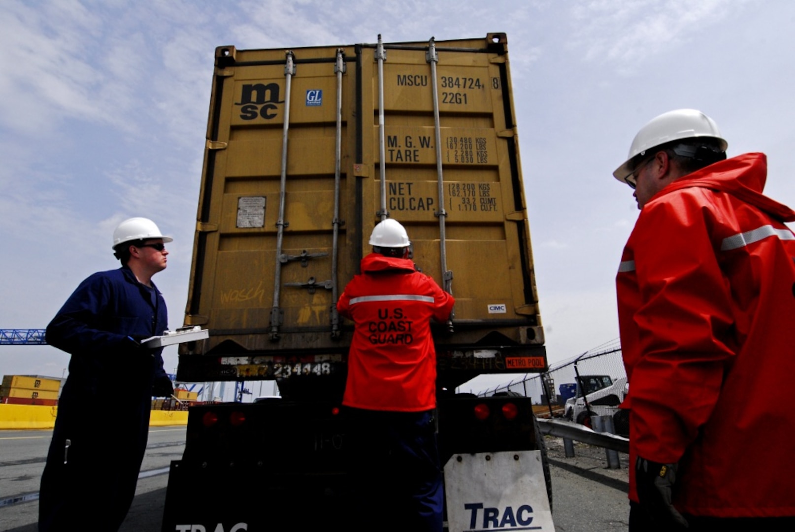 A team of Coast Guard Marine Science Technicians inspect a shipping container on the back of a truck at Conley Terminal in Boston. (U.S. Coast Guard photo by Petty Officer Second Class Luke Pinneo)