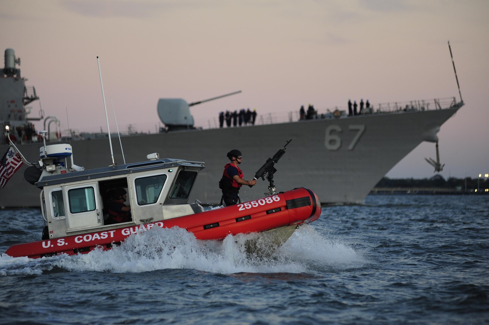 A Coast Guard Maritime Safety and Security Team crew, temporarily deployed from San Francisco, provides an escort for the USS Cole as the Navy destroyer returns to the Norfolk Naval Shipyard. Coast Guard crews worked to provide security zones for the Navy ships returning to harbor after Hurricane Irene. (U.S Coast Guard Photo by Petty Officer 3rd Class David Weydert)