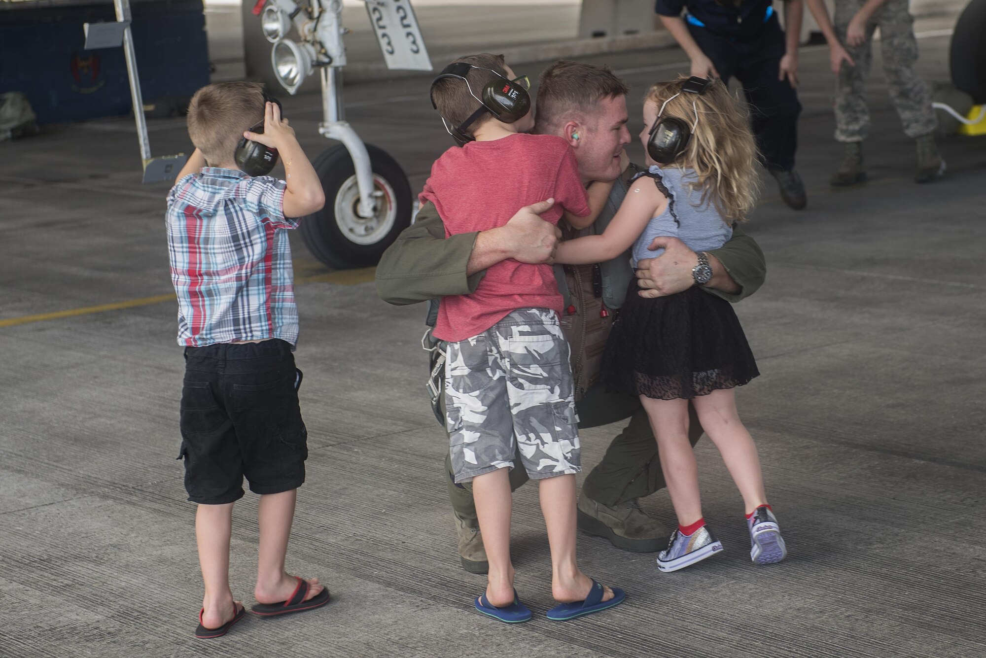 U.S. Air Force Capt. Tyson Hyer, 44th Fighter Squadron pilot, hugs his children after returning from training Oct. 26, 2016, at Kadena Air Base, Japan. The 44th FS spent more than three months training in exercises throughout the Indo-Asia Pacific region. (U.S. Air Force photo by Airman 1st Class Corey M. Pettis/Released)