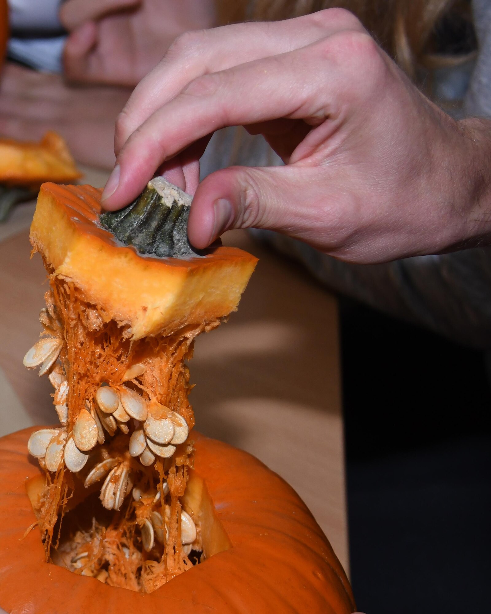 Staff Sgt. Michael Sterchi, 700th Airlift Squadron loadmaster, takes a piece from a pumpkin he is carving with students at Elementary School No. Nine in Gniezno, Poland, Oct. 19, 2016. Pumpkin carving was one of several activities the Airmen participated in on a cultural orientation visit to the school while working with the Polish air force during Aviation Detachment 17-1 in support of Operation Atlantic Resolve. (U.S. Air Force photo by Staff Sgt. Alan Abernethy)