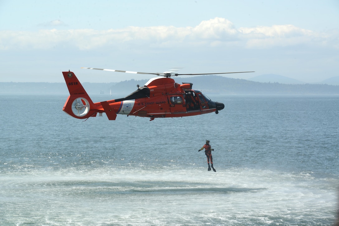 A Coast Guard aircrew aboard an MH-65 Dolphin helicopter, from Air Station Port Angeles, Washington, performs a search and rescue demonstration on the Seattle waterfront during the Seafair Fleet Week. (U.S. Coast Guard photo by Petty Officer 1st Class Zac Crawford)