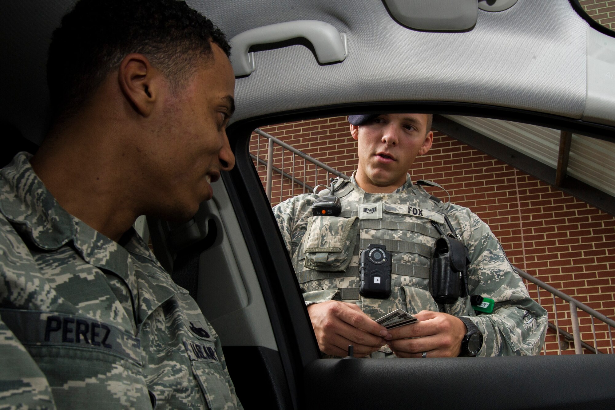 Staff Sgt. Sawyer Fox, 11th Security Forces Squadron response force leader, checks an identification card while wearing a body camera at Joint Base Andrews, Md., Oct. 4, 2016. The cameras are in the process of undergoing an Air Force-level test, which began Oct. 26, to determine their recording quality, usefulness, and how they can be better utilized. Throughout the test plan, approximately nine cameras will be worn at a time by law enforcement officers, lead gate guards, K-9 handlers, the emergency services team, and training and quality care officers. (U.S. Air Force photo by Senior Airman Jordyn Fetter)