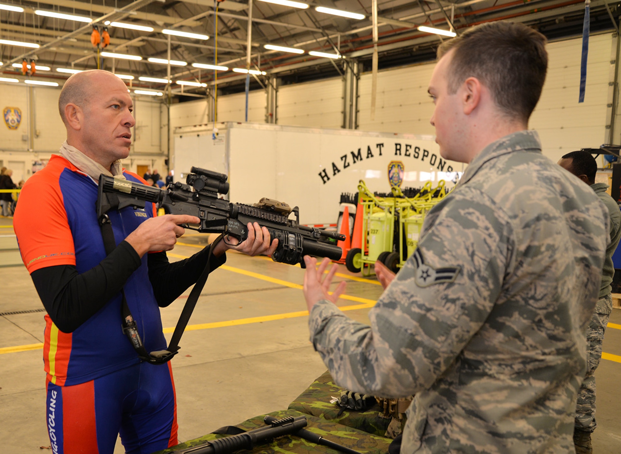 Wayne Harrod, left, amputee and retired British Army infantryman and long-distance cyclist, discusses military weapons with Airman 1st Class Kyle Reppucci, 100th Security Forces Squadron response force member, at the Steel Bones event Oct. 24, 2016, on RAF Mildenhall, England. Steel Bones is a local British organization similar to the Wounded Warrior Program, specifically aimed at amputees and their families. (U.S. Air Force photo by Karen Abeyasekere)