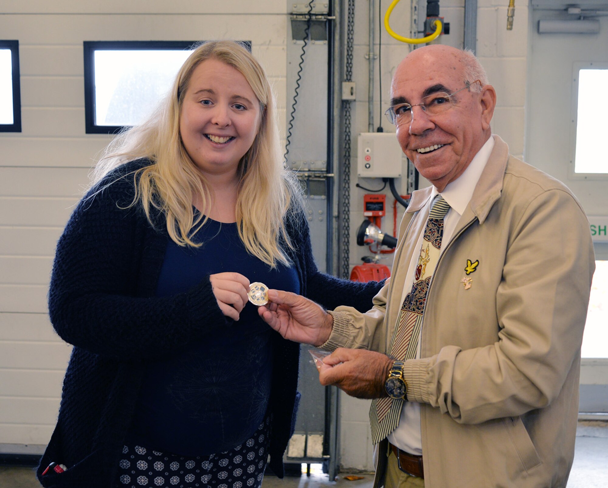 Ken Thompson, right, British-American Committee chairman, presents a BAC coin to Emma Joy-Staines, Steel Bones co-founder, at a Steel Bones event Oct. 24, 2016, on RAF Mildenhall, England. Joy-Staines and her husband, Leigh, began Steel Bones after Leigh’s leg was amputated and the family had difficulty finding support once he left the hospital. (U.S. Air Force photo by Karen Abeyasekere)