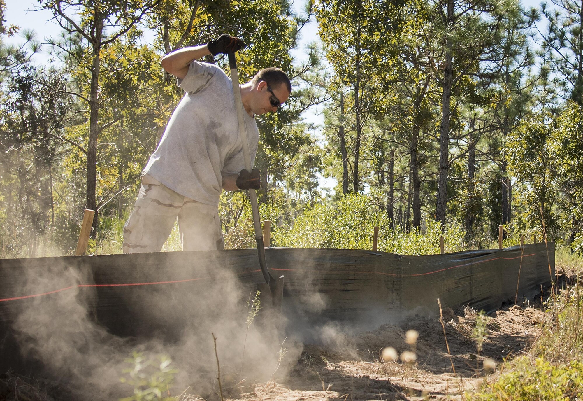 A natural resources volunteer fills in dirt around a silt fence on the Eglin Air Force Base range Oct. 13. The fencing surrounds a new habitat for approximately 250 gopher tortoises. The tortoises were relocated from South Florida to Eglin escaping certain death from urban development. Approximately 500 gopher tortoises will eventually be moved to the range. (U.S. Air Force photo/Samuel King Jr.) 