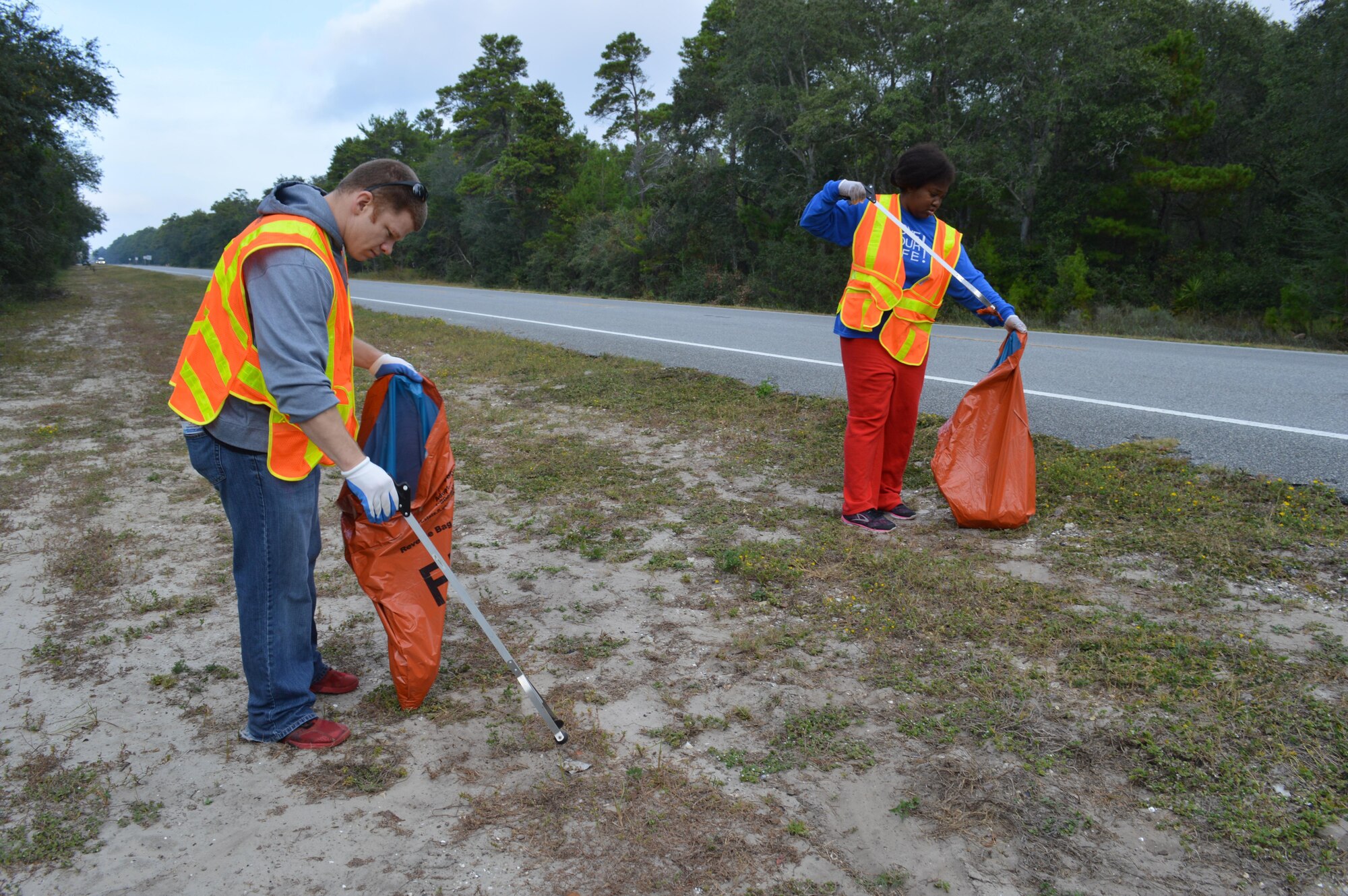 Staff Sgt. Mark Pomory and Tech. Sgt. Danielle Hawkins, Air Forces Northern National Security Emergency Preparedness Directorate Information Technology Specialists, participate in AFNORTH's Combined Enlisted Association's support of the "Adopt a Highway" program, picking up litter items along the CEA-sponsored portion of Highway 98 going toward and into Mexico Beach. (Air Force Photo by Mary McHale)
