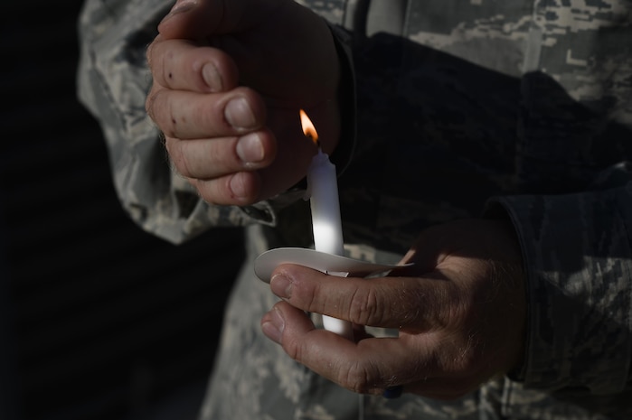 Chaplain (Capt.) Norman Jones, 628th Air Base Wing Chaplain Core chaplain, holds a candle during a candlelit vigil held to raise awareness for domestic abuse victims and honor military families affected by abuse at the Hunt Community Center here, Oct. 24, 2016. With one in three women and one in four men experiencing domestic abuse, more than 10 million people are affected each year.