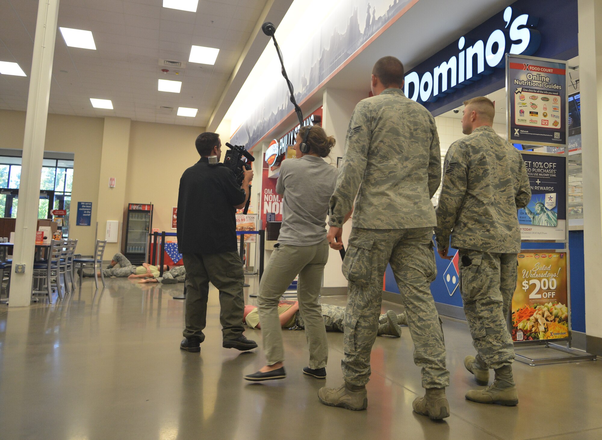 MILO representatives film a mock active-shooter scenario in the Base Exchange food court as Airmen follow their work.  Security Forces personnel will use the film to train on the base’s simulator. (Photo by Todd Berenger)