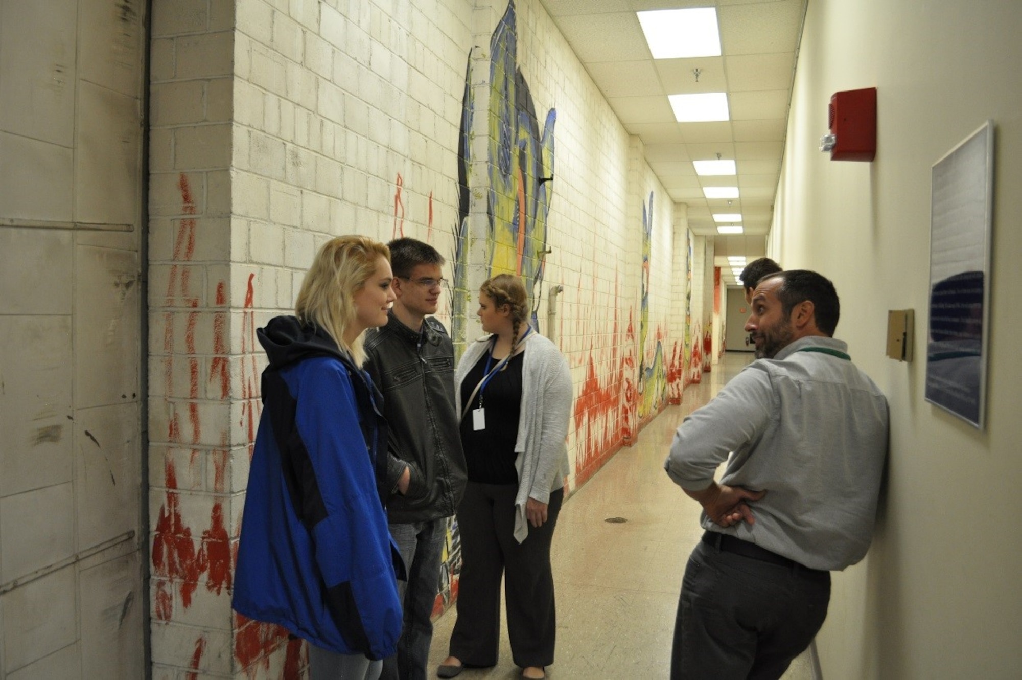 Amelia Kvalheim, a student from Oakwood High School, Scott Cooper, a student from CinDay Academy, Margaret Lingare, a student from Global Impact STEM Academy, and Blake Ullery, a  Milton-Union High School student are taken on a tour of the German POW mural at Building 280 by Michael Vaughn of the 88th Civil Engineer Group as part of the annual Job Shadow Day. (U.S. Air Force photo/Brittney Mitchell)

