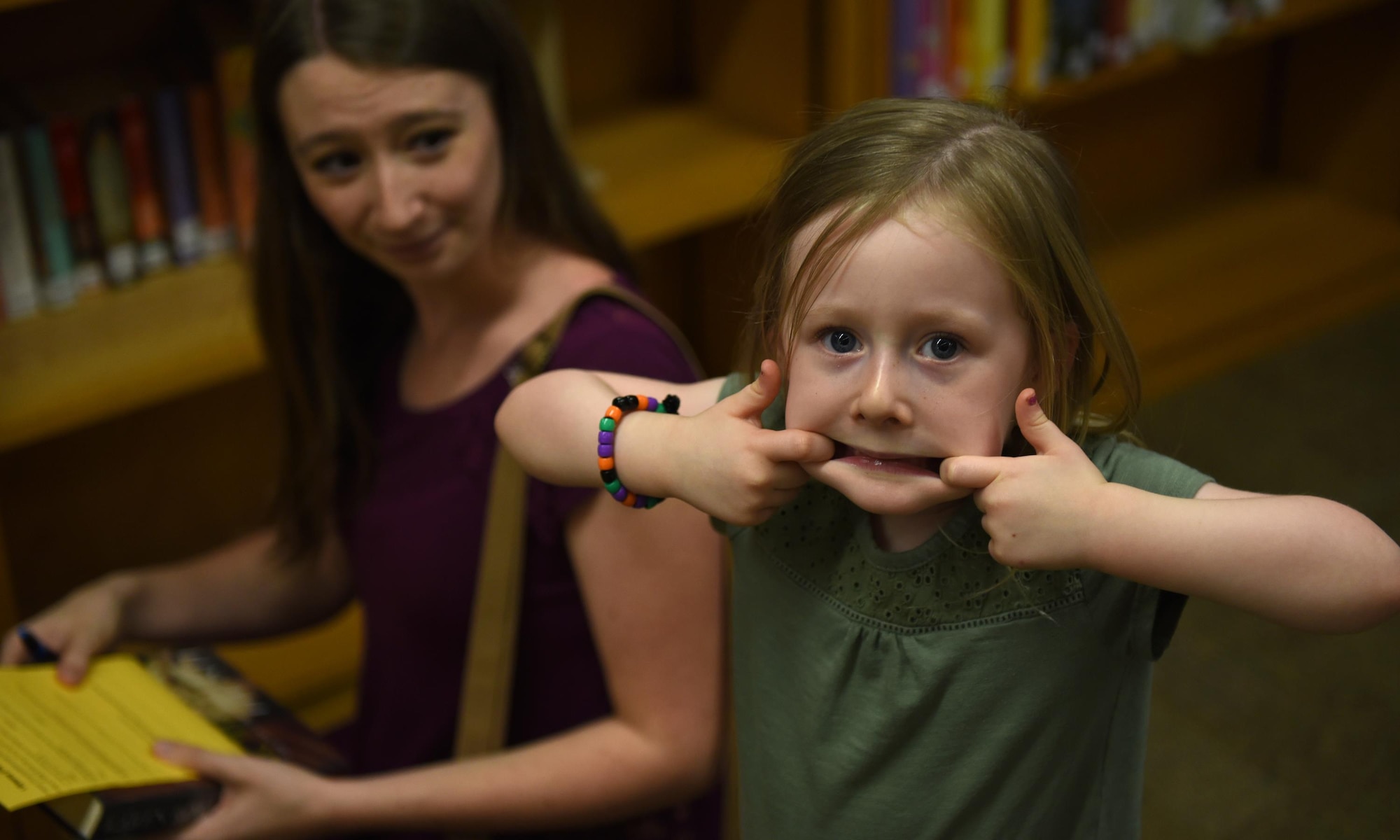Nataly Nock, a Tyndall resident, makes a funny face while taking part in the book scavenger hunt with her mother at the Tyndall Library, Oct. 26, 2016. The Tyndall Library held an open house to inform residents about new service upgrades on offer to all Tyndall Airmen and Families. (U.S. Air Force photo by Airman 1st Class Cody R. Miller/Released) 