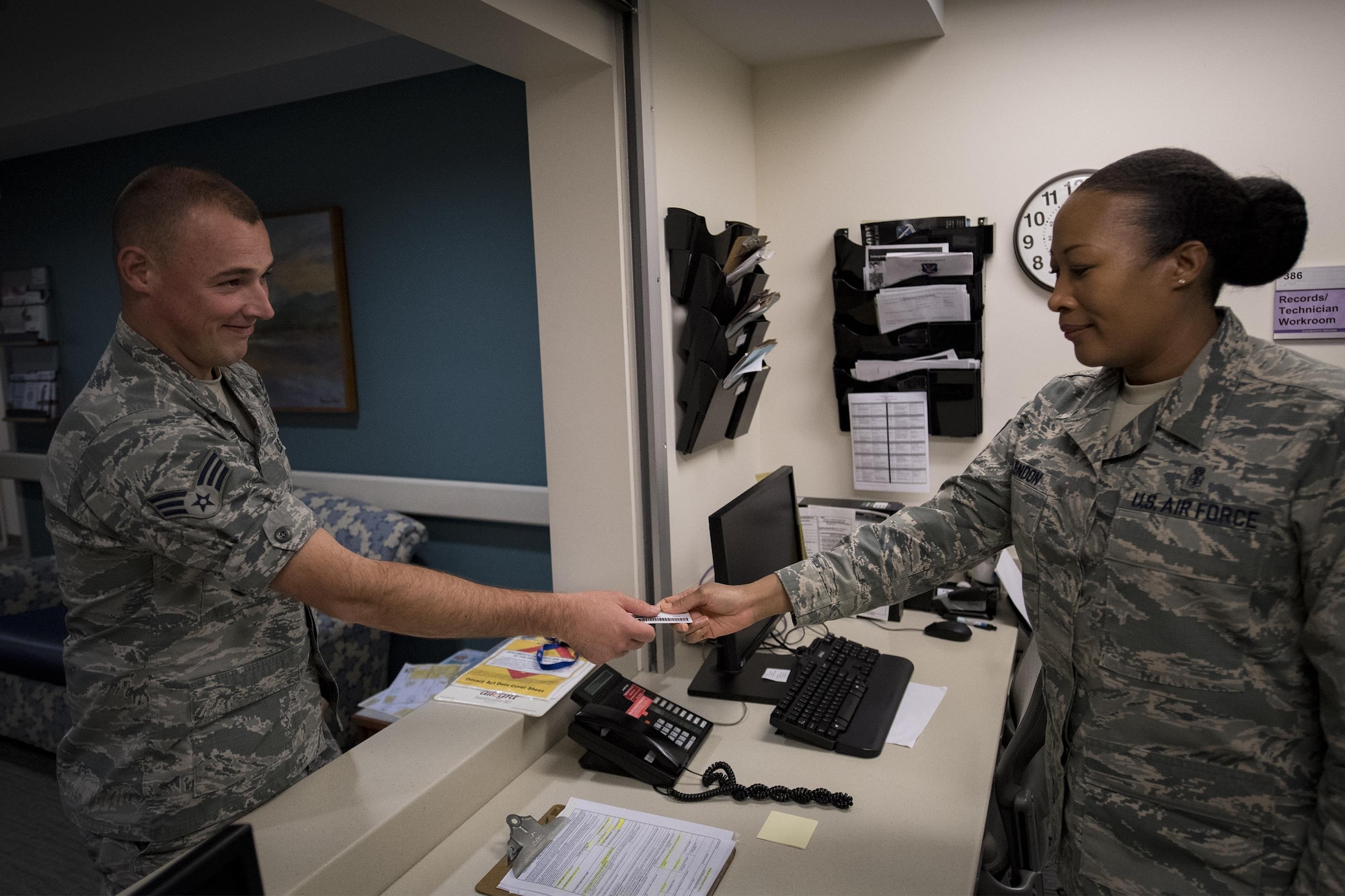 Master Sgt. Tracey McLendon, 23d Medical Support Squadron flight chief of diagnostic imaging, receives an identification card from Senior Airman Jeffrey Nelligan, 355th Medical Support Squadron diagnostic imagining technologist, Oct. 24, 2016, at Moody Air Force Base, Ga. The 23d MDSS radiology diagnostic imaging specialists use sophisticated technology to capture images of the human body to assist physicians in diagnosing patients quickly and accurately. (U.S. Air Force photo by Airman 1st Class Daniel Snider)