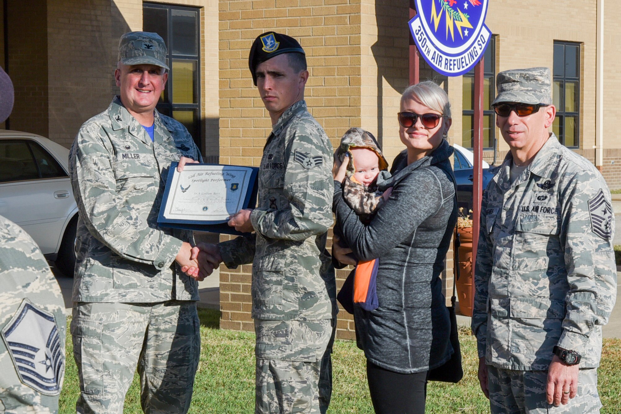 Senior Airman Colton Bess, 22nd Security Forces Squadron police service journeyman, poses with Col. Albert Miller, 22nd Air Refueling Wing commander, Chief Master Sgt. Shawn Hughes, 22nd ARW command chief, Bess’s wife, Bailey, and son, Levi, Oct. 22, 2016, at McConnell Air Force Base, Kan. Bess received the spotlight performer for the week of Oct. 3-7. (U.S. Air Force photo/Senior Airman Christopher Thornbury)