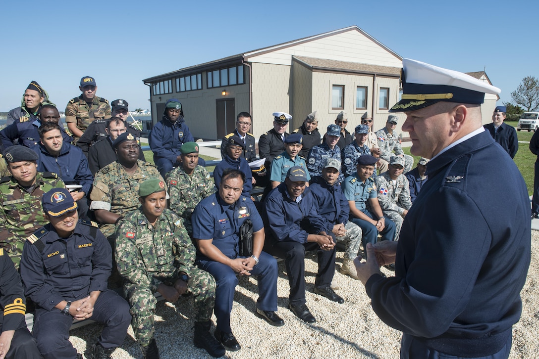 Commanding officer of Coast Guard Training Center Cape May, N.J., speaks to members of foreign military during their visit to the training center. The group is participating in an international training opportunity designed to familiarize foreign military members with the Coast Guard as well as to learn about American history and culture. Twenty-seven countries have members participating in this class. (U.S. Coast Guard photo by Chief Warrant Officer John Edwards/Released)