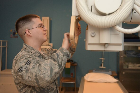 Senior Airman Awstyn Cordova, 5th Medical Support Squadron radiology technologist, adjusts an x-ray tube before an eam at Minot Air Force Base, N.D., Oct. 25, 2016. Radiology technologists forward all captured x-ray imagery to radiologists at Travis AFB, California, for further assessment. (U.S. Air Force photo/Airman 1st Class Jessica Weissman)