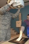 Senior Airman Awstyn Cordova, 5th Medical Support Squadron radiology technologist, positions an x-ray tube over Senior Airman Robert Moon’s, 5th Medical Operations Squadron medical technician, ankle at Minot Air Force Base, N.D., Oct. 25, 2016. Radiology technologists provide accurate x-ray examination images for radiologists to ensure Airmen are healthy and fit for duty. (U.S. Air Force photo/Airman 1st Class Jessica Weissman) 