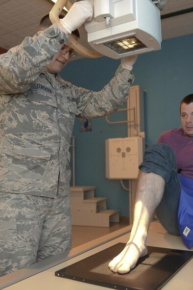 Senior Airman Awstyn Cordova, 5th Medical Support Squadron radiology technologist, positions an x-ray tube over Senior Airman Robert Moon’s, 5th Medical Operations Squadron medical technician, ankle at Minot Air Force Base, N.D., Oct. 25, 2016. Radiology technologists provide accurate x-ray examination images for radiologists to ensure Airmen are healthy and fit for duty. (U.S. Air Force photo/Airman 1st Class Jessica Weissman) 