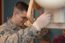 Senior Airman Awstyn Cordova, 5th Medical Support Squadron radiology technologist, adjusts an x-ray tube over a patient at Minot Air Force Base, N.D., Oct. 25, 2016. Radiology technologists provide x-ray images to a monthly average of 120 active duty military, dependent families and retirees.  (U.S. Air Force photo/Airman 1st Class Jessica Weissman)
