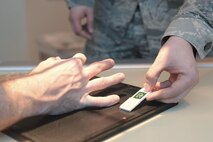 A 5th Medical Support Squadron radiology technologist positions a directional marker onto a film tray at Minot Air Force Base, N.D., Oct. 25, 2016. Markers help radiology technologists identify the correct body part by labeling which direction is visible. (U.S. Air Force photo/Airman 1st Class Jessica Weissman)