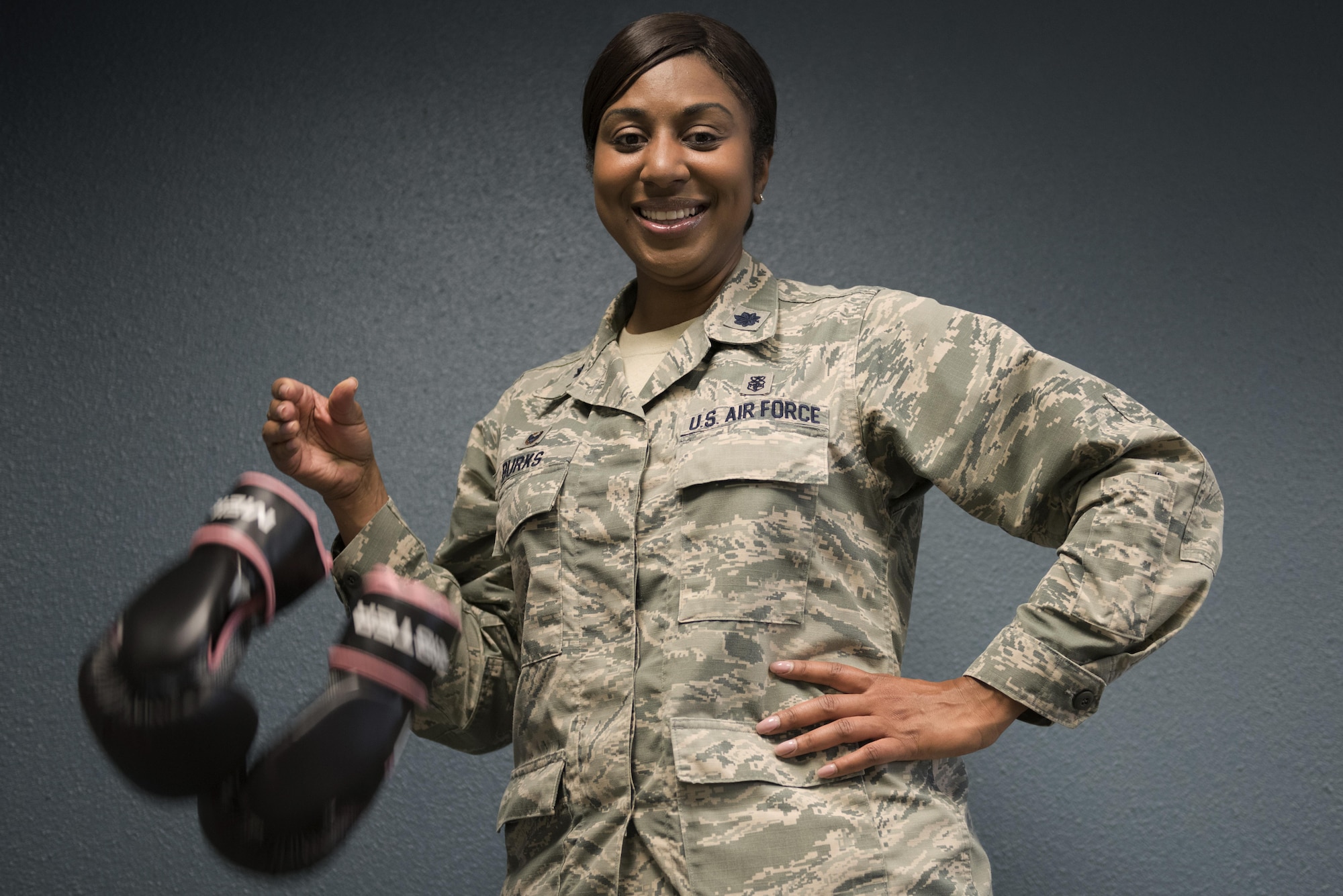 Lt. Col. Felicia Burks, the 92nd Medical Support Squadron commander, drops a pair of boxing gloves Oct. 21, 2016, at Fairchild Air Force Base, Wash. During her fight with cancer, Burks took up boxing as a way of staying physically fit. To her, the dropped gloves signify the end of her fight with cancer. (U.S. Air Force photo/Senior Airman Nick J. Daniello)