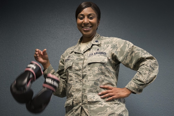 Lt. Col. Felicia Burks, the 92nd Medical Support Squadron commander, drops a pair of boxing gloves Oct. 21, 2016, at Fairchild Air Force Base, Wash. During her fight with cancer, Burks took up boxing as a way of staying physically fit. To her, the dropped gloves signify the end of her fight with cancer. (U.S. Air Force photo/Senior Airman Nick J. Daniello)
