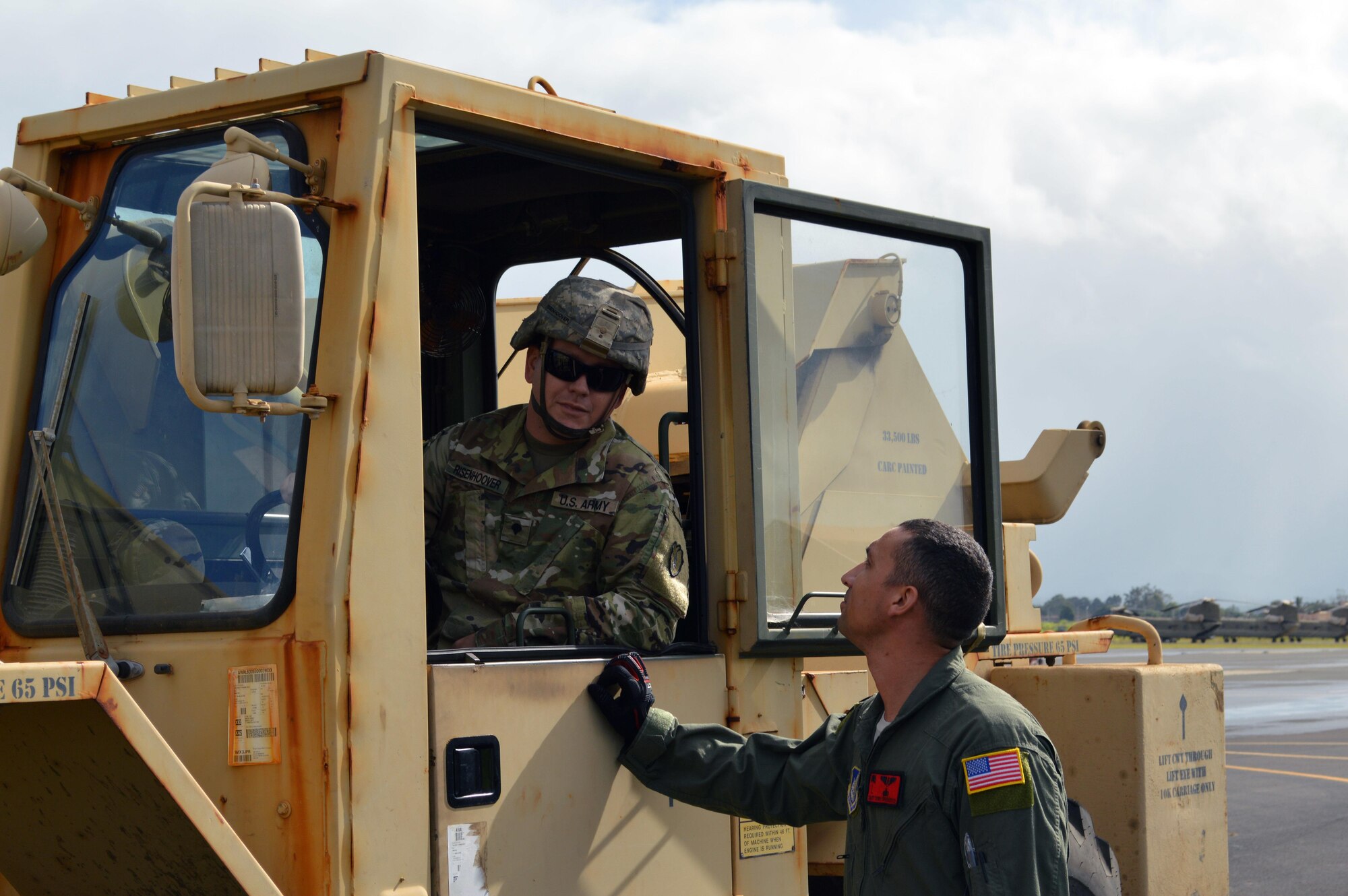 U.S. Air ForceTech. Sgt. Terry Greenwood, a C-17 Globemaster III crewmember assigned to the 535th Airlift Squadron, 15th Wing, speaks to Army Spc. James Risenhoover, a wheeled vehicle mechanic assigned to 3rd Squadron, 4th Cavalry Regiment, 3rd Brigade Combat Team (BCT), 25th Infantry Division, prior to loading equipment aboard the C-17 at Wheeler Army Airfield, Hawaii, on Oct. 24, 2016. The 3rd BCT equipment will be used by the Soldiers sent to Pohakuloa Training Area on the island of Hawaii during Lightning Forge 17. (U.S. Army photo by Staff Sgt. Armando R. Limon)
