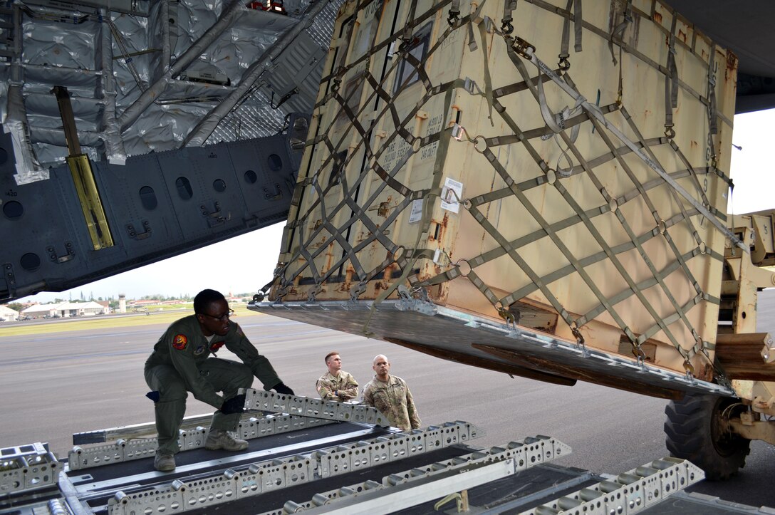 U.S. Air Force Airman 1st Class Shavonnte Coats, a C-17 aircrew member assigned to the 535th Airlift Squadron, 15th Wing, quickly places rollers so a cargo container can be loaded aboard the C-17 at Wheeler Army Airfield, Hawaii, on Oct. 24, 2016. More than 200 Soldiers and equipment from the 3rd Brigade Combat Team, 25th Infantry Division are participating in Lightning Forge 17 at Pohakuloa Training Area on the island of Hawaii. (U.S. Army photo by Staff Sgt. Armando R. Limon)