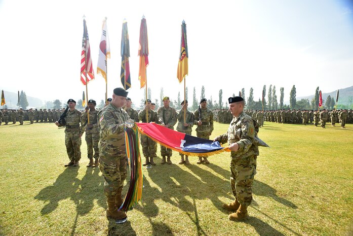 Col. Timothy Hayden (left), 1st Armored Brigade Combat Team, 1st Infantry Division and Command Sgt. Maj. Dale Sump, 1st ABCT, 1st ID command sergeant major, "un-case" the brigade's coloros during a Transfer of Authority ceremony held at Camp Casey on October 27. 1st ABCT, 1st ID is assuming the rotational mission conducted by 1st ABCT, 1st Cavlary Division for the last nine-months. 