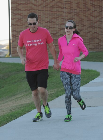 Staff Sgt. Christopher Seigman, the non-commissioned officer in charge of maintenance support assigned to the 28th Munitions Squadron (left), and his spouse Aysley (right), finish the last length of the Pink Day Parade and 5K as part of Breast Cancer Awareness Month at Ellsworth Air Force Base, S.D., Oct. 7, 2016. According to the American Cancer Society, breast cancer is the most common cancer among women in the United States - other than skin cancer. (U.S. Air Force photo by Airman 1st Class Denise M. Jenson)