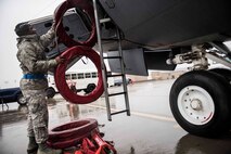 Airman Alvin Carr, 92nd Maintenance Squadron crew chief, hands engine exhaust covers to Capt. Chad Halverstadt, 93rd Air Refueling Squadron pilot, Oct. 27, 2016 at Fairchild Air Force Base, Wash. Flight crew and crew chiefs prepared the KC-135R Stratotanker to execute wing's air refueling mission at a moment's notice. (U.S. Air Force photo/Senior Airman Nick J. Daniello)