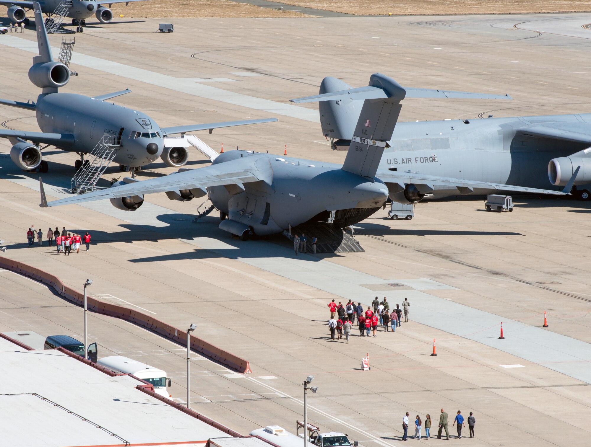 High School students from Northern Calif., walk across the tarmac at Travis Air Force Base, to tour a KC-10 Extender, C-5M Super Galaxy, and a C-17 Globemaster III., Oct. 20, 2016. Travis hosted Junior Reserve Officer Training Corps students from five high schools in Northern Calif. Students toured several aircraft, air traffic control tower, dormitories, and had the opportunity to talk with personnel about military life. (U.S. Air Force photo by Louis Briscese)
