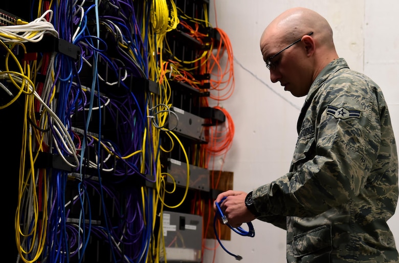 Airman 1st Class Michael De La Mater, 460th Space Communication Squadron network technician, changes out an Ethernet cable inside a communications closet Oct. 20, 2016, at Buckley Air Force Base, Colo. Each communications closet is used to house cables for all the computers within a designated area. (U.S. Air Force photo by Airman Holden S. Faul/ Released)