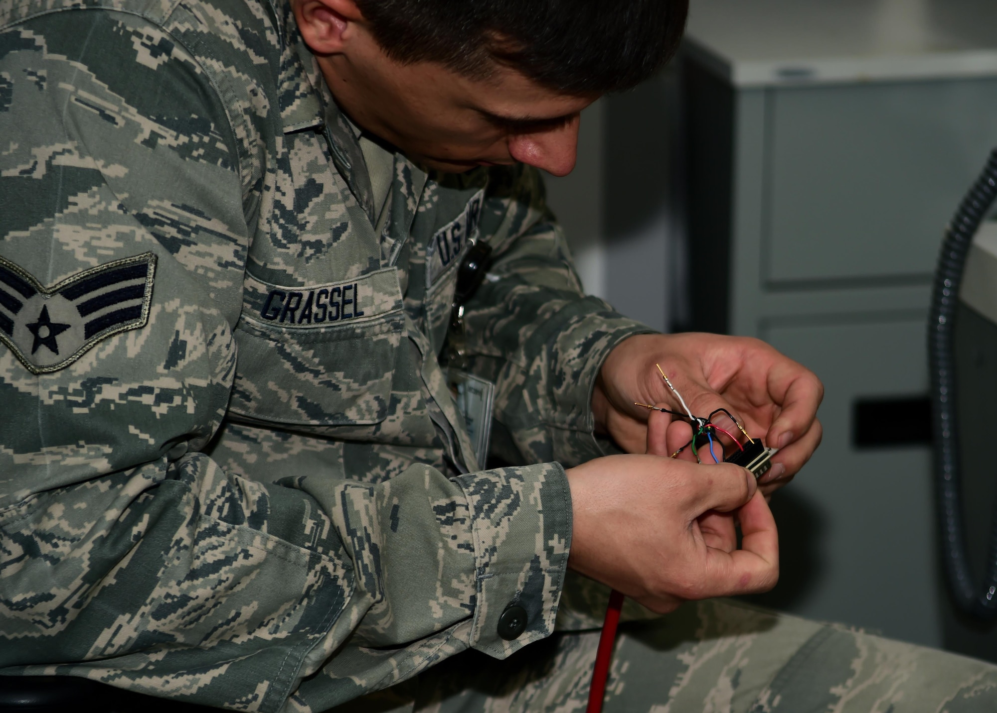 Senior Airman Mark Grassel, 460th Space Communication Squadron Defense Red Switch Network technician, assembles a propriety DB25 amphenol cable to upgrade an existing circuit Oct. 20, 2016, on Buckley Air Force Base, Colo. These circuits are updated routinely to maintain mission readiness. (U.S. Air Force photo by Airman Holden S. Faul/ Released)