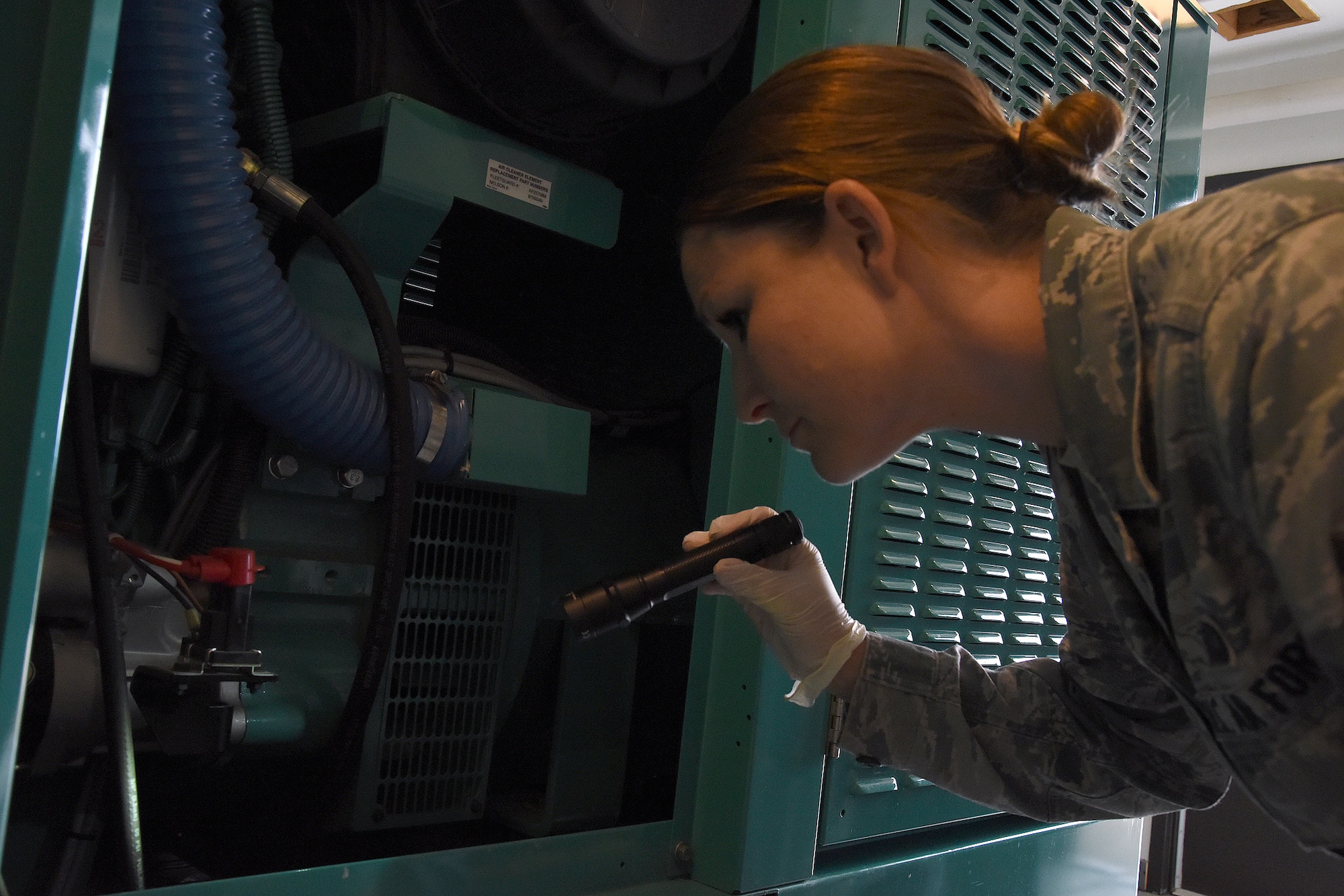 Staff Sgt. Tara Kindermann, 490th Missile Squadron facility manager, inspects the diesel electric unit generator at a missile alert facility Oct. 19, 2016, at Malmstrom Air Force Base, Mont.The DEU provides power to the site when commercial power is unavailable. (U.S. Air Force photo/Senior Airman Jaeda Tookes)