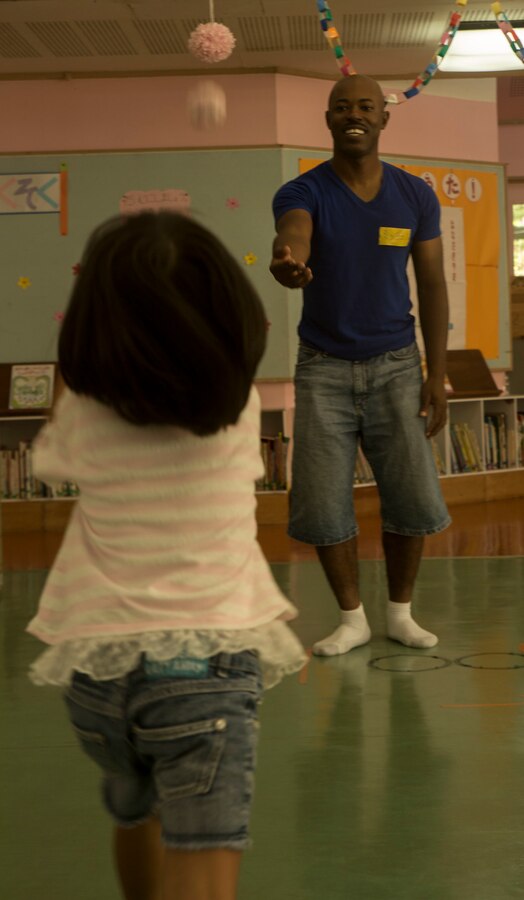 U.S. Marine Corps GySgt. Raetheon W. Mitchell plays catch with a young girl at the Chatan-Daini Kindergarten during a visit to the school in Okinawa, Japan, Oct. 26, 2016. The Marines were able to show the local children the similarities between the U.S. and Japanese cultures through a variety of games and books. Mitchell, from Philadelphia, Pennsylvania, is the motor transportation maintenance chief at Garrison Mobile Equipment, Marine Corps Base Smedley Butler, III Marine Expeditionary Force. (U.S. Marine Corps photo by Lance Cpl. Kelsey Dornfeld)