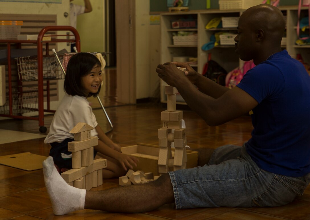 U.S. Marine Corps GySgt. Raetheon W. Mitchell, a motor transportation maintenance chief at Garrison Mobile Equipment, Marine Corps Base Smedley Butler, III Marine Expeditionary Force, builds block towers with a student at the Chatan-Daini Kindergarten during a visit to the school in Okinawa, Japan, Oct. 26, 2016. The Marines were able to show the local children the similarities between U.S. and Japanese cultures through a variety of games and books. (U.S. Marine Corps photo by Lance Cpl. Kelsey Dornfeld)