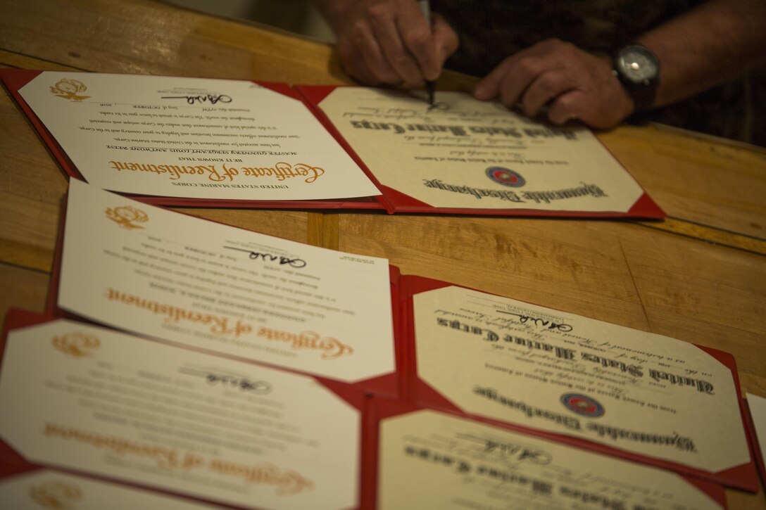 Lt. Gen. Lawrence D. Nicholson, signs off on reenlistment certificates Oct. 27, 2016 at Camp Foster Okinawa, Japan. Twenty one Marines were given the unique opportunity to reenlist on the spot and circumvent routing up a package to headquarters. Monitors and career planners from Manpower Management Division Enlisted Assignments, Headquarters United States Marine Corps, visited Okinawa to help Marines progress in their Marine Corps path. Nicholson is the III Marine Expeditionary commanding general. (U.S. Marine Corps photo by Sgt. Isaac Ibarra/Released)