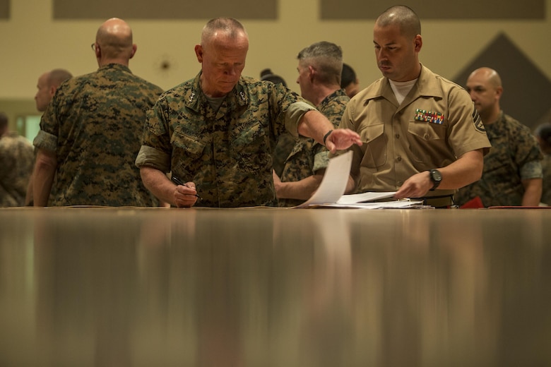 Lt. Gen. Lawrence D. Nicholson, left, signs off on reenlistment certificates Oct. 27, 2016 at Camp Foster Okinawa, Japan. Twenty one Marines were given the unique opportunity to reenlist on the spot and circumvent routing up a package to headquarters. Monitors and career planners from Manpower Management Division Enlisted Assignments, Headquarters United States Marine Corps, visited Okinawa to help Marines progress in their Marine Corps path. Nicholson is the III Marine Expeditionary commanding general. (U.S. Marine Corps photo by Sgt. Isaac Ibarra/Released)