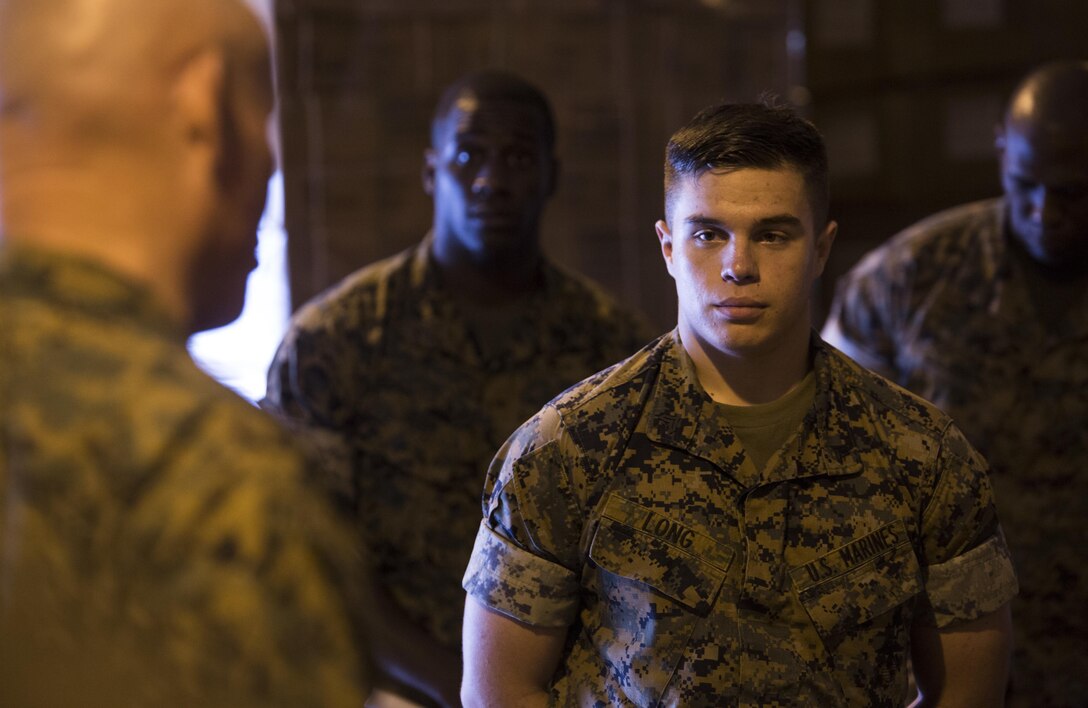 U.S. Marine Corps Cpl. Matthew A. Long, right, a motor transport mechanic with Motor Transport Company, 3rd Marine Logistics Group, III Marine Expeditionary Force, was recognized by Lt. Gen. Lawrence D. Nicholson, the commanding general for III MEF, for winning a Marine Corps wide competition for logistical innovation on Camp Kinser, Okinawa, Japan, October 20, 2016. Long designed a self-aiding attachment to be placed between a Marine and the small arms protective insert plates. Long’s idea for the device began after brainstorming ways to save Marines’ lives with hopes to minimize the time between injury and treatment. (U.S. Marine Corps photo by Sgt. William Hester)