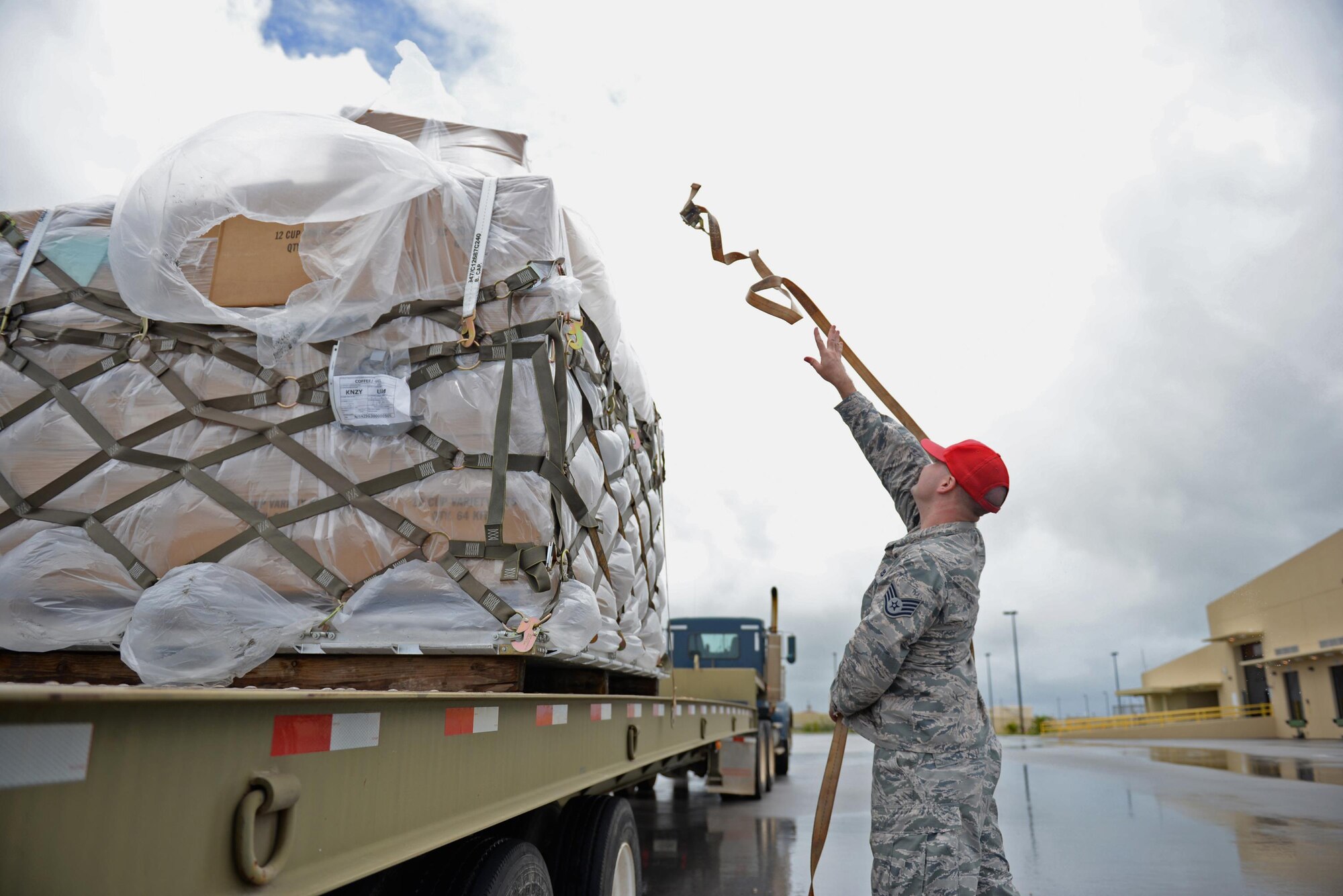 Staff Sgt. Andrew Welch, 554th RED HORSE Squadron construction equipment operator, secures a pallet of coffee to a flatbed truck August 18, 2016, at Andersen Air Force Base, Guam. The 554th RHS supports the 36th Wing Chapel by transporting and storing coffee after it arrives on base. (U.S. Air Force photo by Airman 1st Class Jacob Skovo)