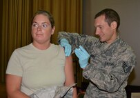Staff Sgt. Zach Nagle administers a flu shot to Tech. Sgt. Crystal Salierno of the 552nd Air Control Wing, as part of the 72nd Medical Group’s two-day stint at the base theater. All active duty military members were eligible to receive their flu shot during this time. (Air Force photo by Jillian Coleman)